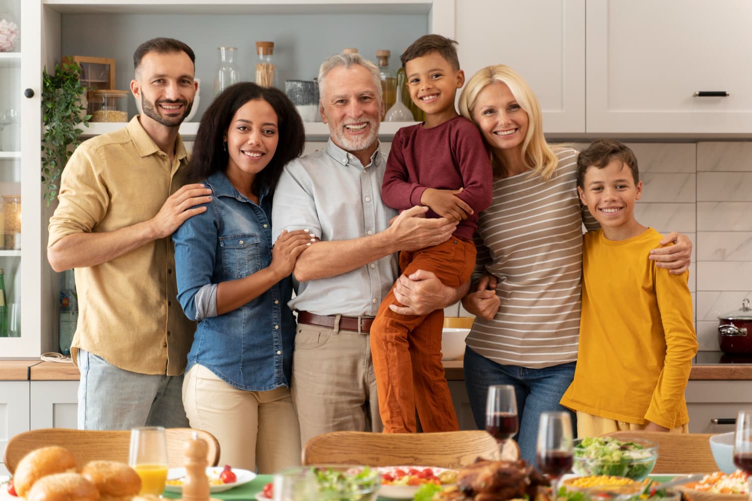 Multi-generational family smiling together in a kitchen